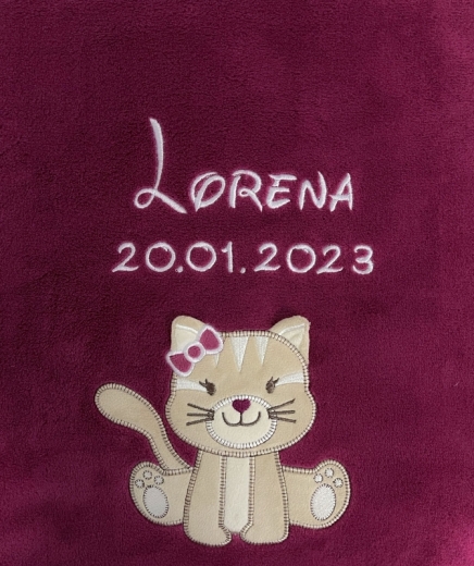 Couverture bébé douillette couleur baie, broderies blanches. En haut, prénom « Lorena » en police élégante, dessous, date « 20/01/2023 ». En bas, chat beige avec nœud rose à l’oreille, moustaches et pattes.